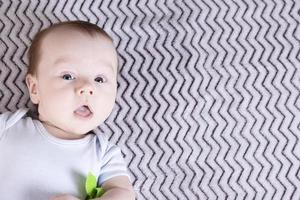 Cute baby boy playing with a colored toy. Copy space. photo