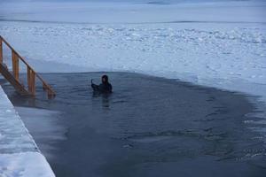 A man in a diving suit. A professional rescue diver is in the hole and ready to help a drowning person. photo