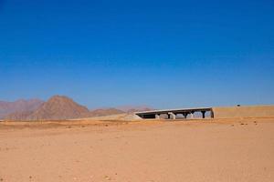 A road with a bridge through the desert. photo