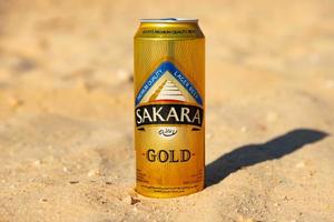 Sharm El Sheikh, Egypt - January 21, 2021 - SAKARA GOLD beer in a metal can, a beer can on the background of the Desert. photo