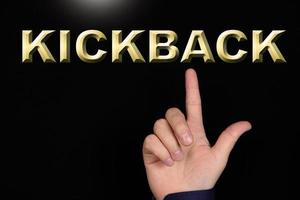 KICKBACK text, a word written on a black background pointed to by a hand with the index finger of a person. photo