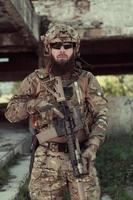 A bearded soldier in uniform of special forces in a dangerous military action in a dangerous enemy area. Selective focus photo