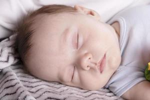 Adorable baby sleeping relaxed and sprawl in parent's bed photo