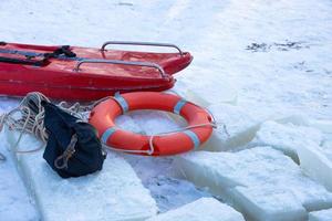 Lifebuoy on the ice of a frozen river photo