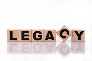 LEGACY word, text, written on wooden cubes, building blocks, over white background with reflection. photo