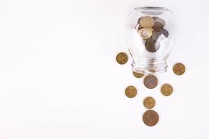 Metal coins pouring out of the can, on a white background. Copy space. photo