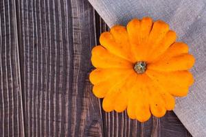 Fresh yellow pumpkin, medium size, on linen, on a wooden surface. Copy space. photo