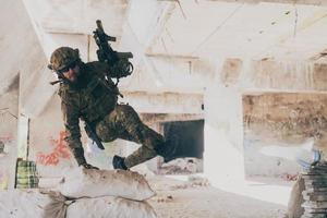 A bearded soldier in uniform of special forces in a dangerous military action in a dangerous enemy area. Selective focus photo