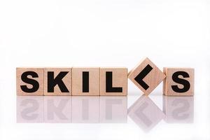 SKILLS word, text, written on wooden cubes, building blocks, over white background with reflection. photo