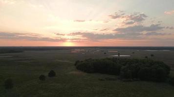 Sun rise shines over a landscape of fields and trees video