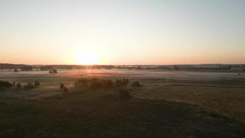 Sun rise shines over a landscape of fields and trees video