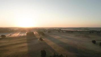 Sun light shines over a foggy field video