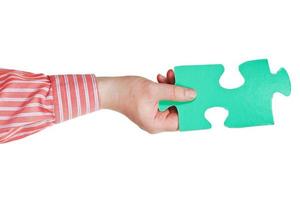 male hand holding big green paper puzzle piece photo