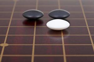 three stones during go game playing on goban photo