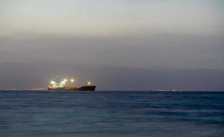 illuminated cargo ship in Red sea at night photo