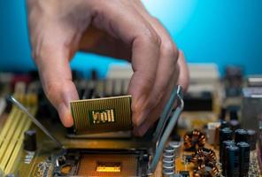 Electronic engineer hand putting computer chip on socket. Chipset on electronic circuit board of PC mother board. CPU chip. Electronic components. Computer hardware. Upgrade computer processor chip. photo