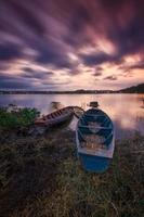 two fishing boats leaning against the amazing cloudy sky background photo