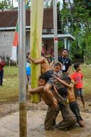 Blitar, indonesia - September 11th 2022. Children help each other in a areca climbing competition to celebrate Indonesian Independence Day in Blitar, East Java, Indonesia photo