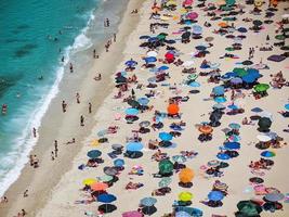 tourists and umbrellas on the beach photo