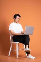 man sitting on chair  isolated on orange background photo