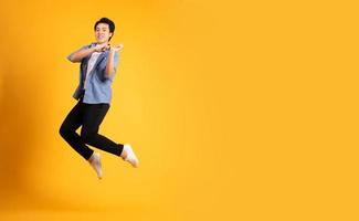 full body image of asian man posing on yellow background photo