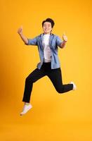 full body image of asian man posing on yellow background photo