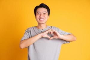 Asian young man posing on a yellow background photo