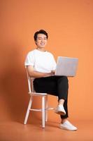 man sitting on chair  isolated on orange background photo