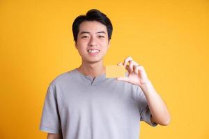 Asian young man posing on a yellow background photo