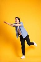 full body image of asian man posing on yellow background photo