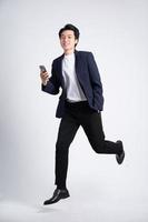 Young business man wearing a suit posing on a white background photo