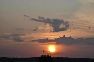 Beautiful sunset summer sky clouds and a flying plane. Sunset evening sky in the evening. photo