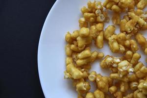 Sweet snack chuck-chuck in a package on a white plate. Honey snack made of dough close-up. photo