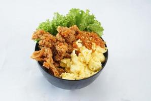 Crispy fried chicken and eggs in a black bowl photo