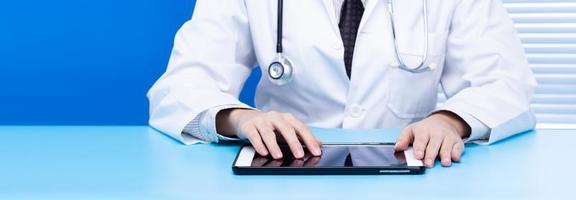 concepto de búsqueda de redes de información de datos de Internet para servicios médicos y sanitarios. búsqueda de médicos navegando por la barra de Internet sosteniendo el fondo de la tableta en la sala de oficina azul, espacio de copia foto