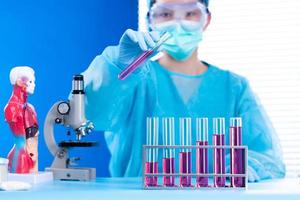 Lab assistant uniform with mask gloves holding test tube with science laboratory research sample while analyzing development on biology chemical as graph growth increase investment revenue, copy space photo