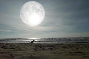 Landscape moon over the horizon on sea and moonlight. Panorama with the luna of night. Grand mystical fantastic view. Mid-Autumn Festival or Halloween concept. The full moon was furnished by NASA. photo