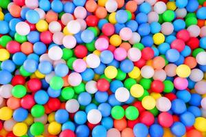 Bolas de plástico multicolores y altamente saturadas, en una piscina de bolas de juego suave, en un parque de juegos para niños. globo colorido. foto