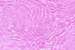 Defocus blurred transparent purple colored clear calm water surface texture with splash, bubble. Shining purple water ripple background. Surface of water in swimming pool. Tropical purple water color. photo