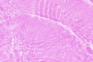 desenfoque borrosa transparente de color púrpura claro agua tranquila textura de la superficie con salpicaduras, burbujas. fondo de ondulación de agua púrpura brillante. superficie del agua en la piscina. color de agua púrpura tropical. foto