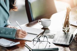 Investment concepts, women holding pen with notebook and computers to analyze stock markets, quantitative data collection, financial statement analysis, profitability through internet technology. photo