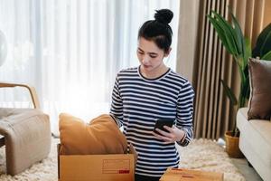 Online merchandising business idea, a beautiful girl is packing pillows in a shipping box to prepare to send items to customers according to orders received from customers. photo