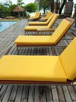 Sun or beach beds beside the pool which nearby a beach with background of sea in long sight. photo