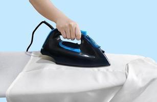 woman ironing clothes front view lonely on a blue background blue iron on white table photo