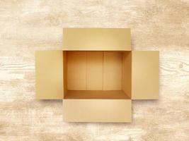 Brown blank paper box isolated on wooden background. photo