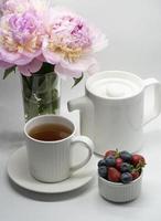 Cup of tea, peony and berries. photo