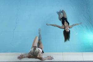 foto retrovisora de dos mujeres jóvenes relajándose en la piscina en un spa