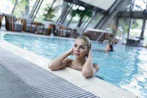 Young beautiful woman enjoying in hot tub while spending relaxing day at health spa. photo