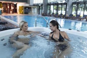 Two young women enjoying and relaxing in SPA hot tube. photo