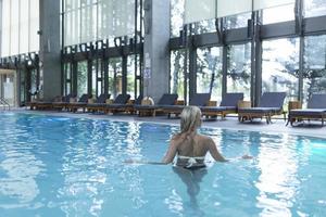 Side view of a Caucasian woman resting at poolside. She is enjoying a quiet weekend at the spa. photo